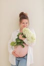 healthy pregnancy. Side view pregnant woman with big belly advanced pregnancy in hands. girl holding big bouquet of