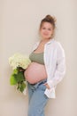 healthy pregnancy. Side view pregnant woman with big belly advanced pregnancy in hands. girl holding big bouquet of