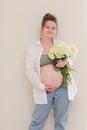 healthy pregnancy. Side view pregnant woman with big belly advanced pregnancy in hands. girl holding big bouquet of