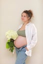 healthy pregnancy. Side view pregnant woman with big belly advanced pregnancy in hands. girl holding big bouquet of