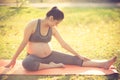 Healthy pregnant woman doing yoga in nature outdoors. Royalty Free Stock Photo