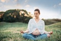 Healthy Pregnant woman doing yoga outdoors in sunny summer day, lifestyle photo. Royalty Free Stock Photo