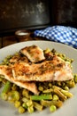 Baked trout with olive oil, lemon juice and herbs served with green beans, peas, and asparagus Royalty Free Stock Photo