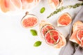 Healthy quick breakfast toast recipe - fresh bruschetta with ripe fig, cheese, prosciutto and herbs over white table