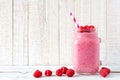 Raspberry smoothie in a mason jar with berries against white wood Royalty Free Stock Photo