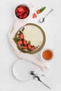 Healthy raw almond cake with strawberries and nuts decorated with mint and chocolate on white table. Cup of tea. Top view Royalty Free Stock Photo