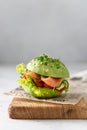 Healthy raw avocado burger with salted salmon, fresh vegetables and microgreen. Raw food diet recipe, healthy nutrition. Side view Royalty Free Stock Photo