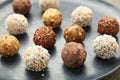 Healthy raw energy balls. Candy vegan balls of dates, nuts and coconut on dark plate. Top view, concept of useful home-made Royalty Free Stock Photo