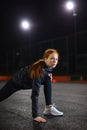 Healthy redhead female athlete stretching legs for warming up before urban fitness Royalty Free Stock Photo