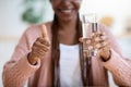 Healthy Refreshment. African American Woman Holding Glass With Mineral Water In Kitchen Royalty Free Stock Photo