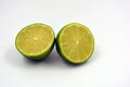 Healthy ripe delicious fruits for human health. Juicy fruits of green lime. Two halves of lime located on a white background. Royalty Free Stock Photo