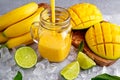 Healthy ripe Yellow Banana Mango Smoothie with slices of Lime, mint and ice