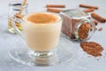 Healthy rooibos red tea latte topped with cinnamon, in glass cup and ingredients on background Royalty Free Stock Photo