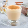 Healthy rooibos red tea latte topped with cinnamon, in glass cup and ingredients on background, square format Royalty Free Stock Photo