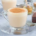 Healthy rooibos red tea latte topped with cinnamon, in glass cup and ingredients on background, square Royalty Free Stock Photo