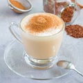 Healthy rooibos red tea latte topped with cinnamon, in a glass cup and ingredients on background, square Royalty Free Stock Photo