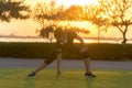 Healthy Runner asian woman athlete stretching legs for warming up before running in the park on sunset.