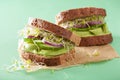 Healthy rye sandwich with avocado cucumber alfalfa sprouts