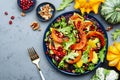 Healthy salad with baked pumpkin slices, red cabbage, avocado, lettuce, arugula, pomegranate and nuts. Vegan vegetarian eating, Royalty Free Stock Photo