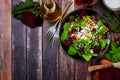 Healthy salad with beets, mixed greens, carrots and feta cheese, corner border against rustic wood