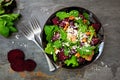 Healthy salad with beets, mixed greens, carrots and feta cheese, above view scene against slate