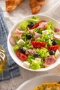 Healthy salad in a bowl with olives, raddishes, tomato, cheese and lean ham served for breakfast Royalty Free Stock Photo