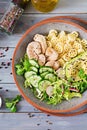 Healthy salad with chicken, avocado, cucumber, lettuce, radish and pasta on dark background. Proper nutrition. Dietary menu. Dinn