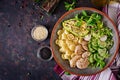 Healthy salad with chicken, avocado, cucumber, lettuce, radish and pasta on dark background. Proper nutrition. Dietary menu. Dinn