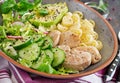 Healthy salad with chicken, avocado, cucumber, lettuce, radish and pasta on dark background. Proper nutrition. Dietary menu.