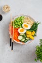 Healthy salad with couscous, carrots, cucumber, green beans, soybeans, corn and an egg on a gray concrete background. Food and Royalty Free Stock Photo