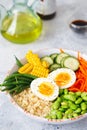 Healthy salad with couscous, carrots, cucumber, green beans, soybeans, corn and an egg on a gray concrete background. Food and Royalty Free Stock Photo