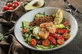 Healthy salad with fillet salmon, quinoa, avocado sauce, grilled pepper, tomatoes, lettuce, arugula in plate on wooden background Royalty Free Stock Photo