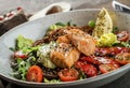 Healthy salad with fillet salmon, quinoa, avocado sauce, grilled pepper, tomatoes, lettuce, arugula in plate on wooden background Royalty Free Stock Photo