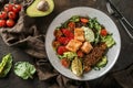 Healthy salad with fillet salmon, quinoa, avocado sauce, grilled pepper, tomatoes, lettuce, arugula in plate on wooden background Royalty Free Stock Photo