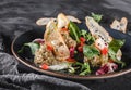 Healthy salad of grilled eggplant, arugula, spinach, tomato, croutons and sauce in a ceramic plate over grey background Royalty Free Stock Photo