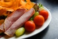 Healthy salad of ham, tomatoes, carrots, bananas, rocket, lettuce green olives and grapes.