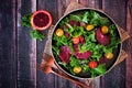 Healthy salad with kale and red blood oranges. Above view table scene against dark wood. Royalty Free Stock Photo