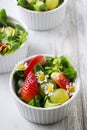 Salad with lamb`s lettuce Valerianella locusta, strawberries, grapes and edible chamomile flowers
