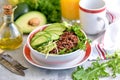 Healthy salad with quinoa, avocado, cucumber and radish with lettuce leaf and olive oil.