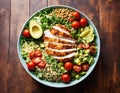 Healthy salad with quinoa, cherry tomatoes, chicken meat, avocado, lime and mixed greens, lettuce, parsley on a wooden table. Royalty Free Stock Photo