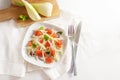 Healthy salad from raw fennel slices, grapefruit and red onions on a white table, copy space, high angle view from above