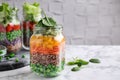 Healthy salads in glass jars on table. Space for text