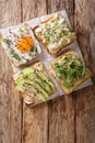 Healthy sandwiches with hummus, avocado, feta cheese, microgreen and egg closeup. Vertical top view