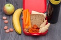 Healthy school lunch box with sandwich, apple, banana, almonds, dry fruits, water, natural candies, carrot, biscuits Royalty Free Stock Photo