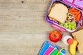 Healthy school lunch and school supplies side border on a wood background Royalty Free Stock Photo