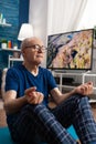 Healthy senior man sitting comfortable in lotus position on yoga mat with closed eyes Royalty Free Stock Photo