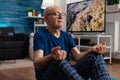 Healthy senior man sitting comfortable in lotus position on yoga mat with closed eyes Royalty Free Stock Photo