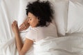 Healthy serene african girl sleeping in comfortable bed, top view