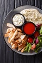 Healthy shawarma plate with chicken, hummus, salad and sauces close-up on a table. Vertical top view Royalty Free Stock Photo