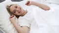 Healthy sleep on orthopedic mattress, happy teenage girl waking up with smile